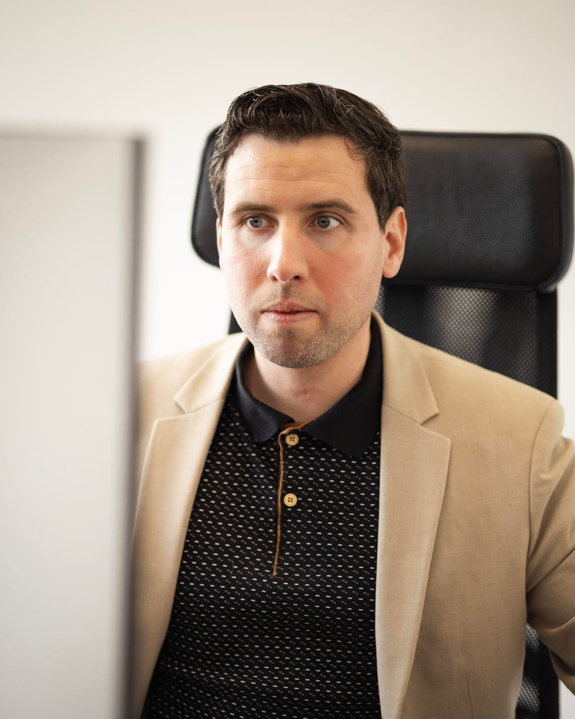 Portrait de Grégory Di Palma assis à son poste de travail, regard posé, entre deux écrans